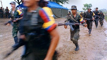 PAZ RECONCILIACIÓN FARC SAN VICENTE, COLOMBIA - APRIL 29: Guerrillas of the Revolutionary Armed Forces of Columbia retreat from San Vicente del Caguan, after the launcing of the victory party of Bolivia, 29 April 2000. Guerrilleros de las Fuerzas Armadas Revolucionarias de Colombia FARC se retiran de San Vicente del Caguan, tras el lanzamiento del Partido Bolivariano, el 29 de abril de 2000. El Partido Bolivariano actuara desde la clandestinidad para proteger a sus integrantes de los grupos paramilitares, fue fundado en medio del rechazo militar y politico por el anuncio previo de que sera un partido para la guerra. (Photo credit should read WILIAM MARTINEZ/AFP/Getty Images)