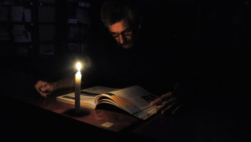 A man reads with a candle's light during a power cut in the border state of San Cristobal, Venezuela, 600 km west of Caracas on April 25, 2016. Recession-hit Venezuela will turn off the electricity supply in its 10 most populous states for four hours a day for 40 days to deal with a severe power shortage, the government said Thursday. / AFP / GEORGE CASTELLANOS (Photo credit should read GEORGE CASTELLANOS/AFP/Getty Images)