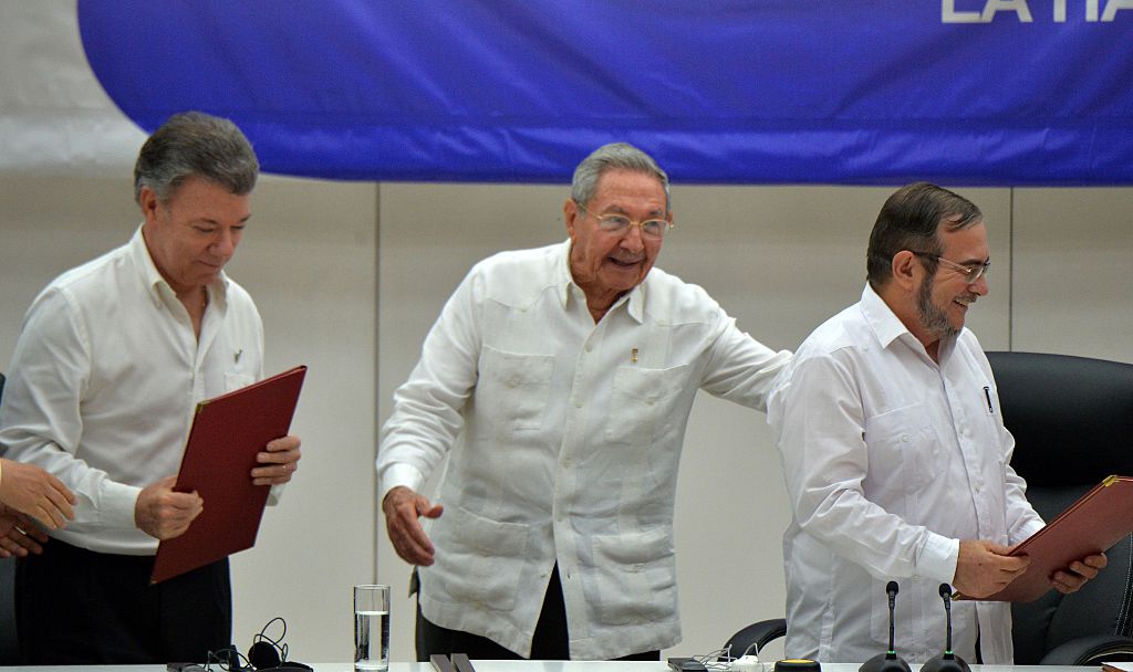 Colombia's President Juan Manuel Santos (L), Cuban President Raul Castro (C) and Timoleon Jimenez, aka "Timochenko" (R), head of the FARC leftist guerrilla, during the signing of the ceasefire in Havana on June 23, 2016. Colombia's government and the FARC guerrilla force signed a definitive ceasefire Thursday, taking one of the last crucial steps toward ending Latin America's longest civil war. / AFP / ADALBERTO ROQUE (Photo credit should read ADALBERTO ROQUE/AFP/Getty Images)