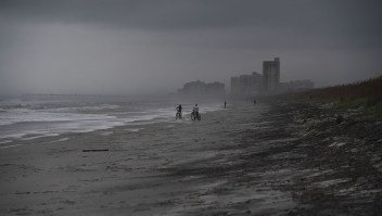 People bike on the beach ahead of hurricane Matthew in Atlantic Beach, Florida, on October 5, 2016. The United States began evacuating coastal areas as Hurricane Matthew churned toward the Bahamas, after killing at least nine people in the Caribbean in a maelstrom of wind, mud and water. / AFP / Jewel SAMAD (Photo credit should read JEWEL SAMAD/AFP/Getty Images)