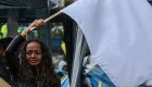 TOPSHOT - A woman cries as she flutters a white flag during a demo for the immediate implementation of the agreement between the Colombian government and the FARC guerrillas at Bolivar Square in Bogota on November 18, 2016. / AFP / Luis Acosta (Photo credit should read LUIS ACOSTA/AFP/Getty Images)