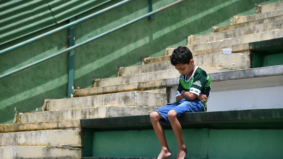 A boy sits alone on the stands during a tribute to the players of Brazilian team Chapecoense Real who were killed in a plane accident in the Colombian mountains, at the club's Arena Conda stadium in Chapeco, in the southern Brazilian state of Santa Catarina, on November 29, 2016. Players of the Chapecoense were among 81 people on board the doomed flight that crashed into mountains in northwestern Colombia, in which officials said just six people were thought to have survived, including three of the players. Chapecoense had risen from obscurity to make it to the Copa Sudamericana finals scheduled for Wednesday against Atletico Nacional of Colombia. / AFP / Nelson ALMEIDA (Photo credit should read NELSON ALMEIDA/AFP/Getty Images)