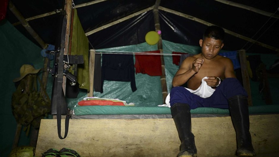 A FARC guerillas member prepares his shirt at the 34 Alberto Martinez camp front just days before their demobilization to the final concentration zones, in Vegaez municipality, Antioquia department, Colombia on December 30, 2016. The Colombian government signed a final peace agreement with the FARC guerrilla on November 26 to be implemented within the next six months, during which FARC members will give up their weapons and start their transition to be reintegrated into society. / AFP / STR / RAUL ARBOLEDA (Photo credit should read RAUL ARBOLEDA/AFP/Getty Images)