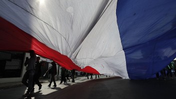 People hold a large Paraguayan flag during a demonstration against a new tax law, in Asuncion on October 19, 2015. The protesters, who are owners and employees from about 300 cooperative businesses, said that they are demonstrating against a new law that establishes a value-added tax of 10 percent to their services. AFP PHOTO / NORBERTO DUARTE (Photo credit should read NORBERTO DUARTE/AFP/Getty Images)