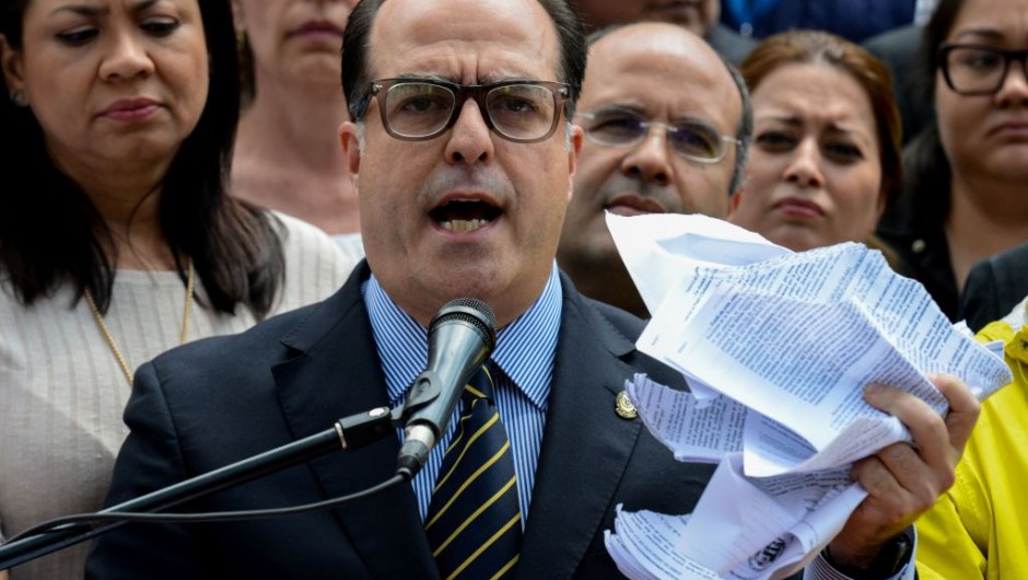 The president of Venezuela's National Assembly Julio Borges, holds a tore copy of a sentence from Venezuela's Supreme Court granting itself legislative powers, as he speaks during a press conference in Caracas on March 30, 2017. Venezuela's Supreme Court took over legislative powers Thursday from the opposition-majority National Assembly, whose speaker accused leftist President Nicolas Maduro of staging a "coup." / AFP PHOTO / FEDERICO PARRA (Photo credit should read FEDERICO PARRA/AFP/Getty Images)