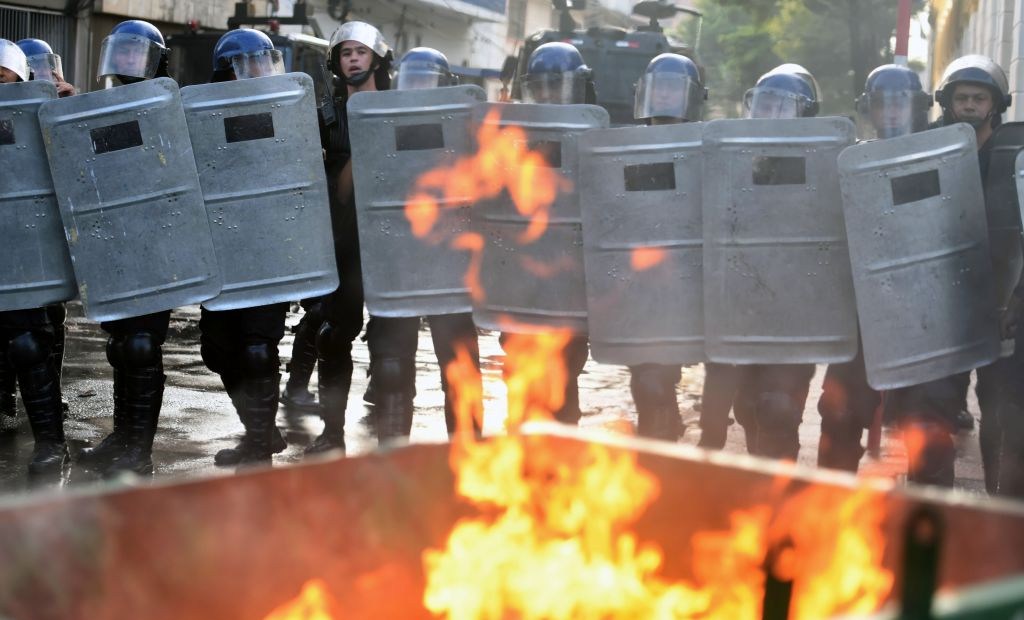 Riot police agents holding shields crack down on a protest against the approval of a constitutional amendment for presidential reelection, outside Congress in Asuncion, on March 31, 2017. Ruling Colorado party senators and their allies, in a so-called "parallel Senate", unexpectedly approved an amendment Friday that would allow President Horacio Cartes to run for reelection in 2018, triggering protests that led to clashes between opposition demonstrators and the police. / AFP PHOTO / NORBERTO DUARTE (Photo credit should read NORBERTO DUARTE/AFP/Getty Images)