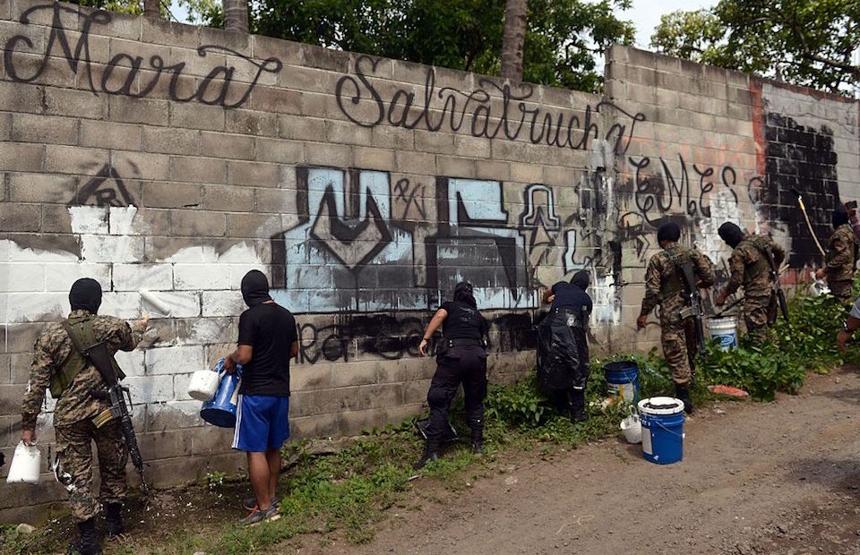 Police officers and soldiers paint over graffiti associated with the Mara Salvatrucha gang in Quezaltepeque, a town 15 km from San Salvador, in an operation to take back gang-controlled neighborhoods, on June 7, 2016. The Salvatrucha (MS-13) and 18th Street gangs are the main cause of the escalation of violence plaguing El Salvador, where an estimated 60,000 people belong to gangs, 15,000 of them in prison. / AFP / Marvin RECINOS (Photo credit should read MARVIN RECINOS/AFP/Getty Images)