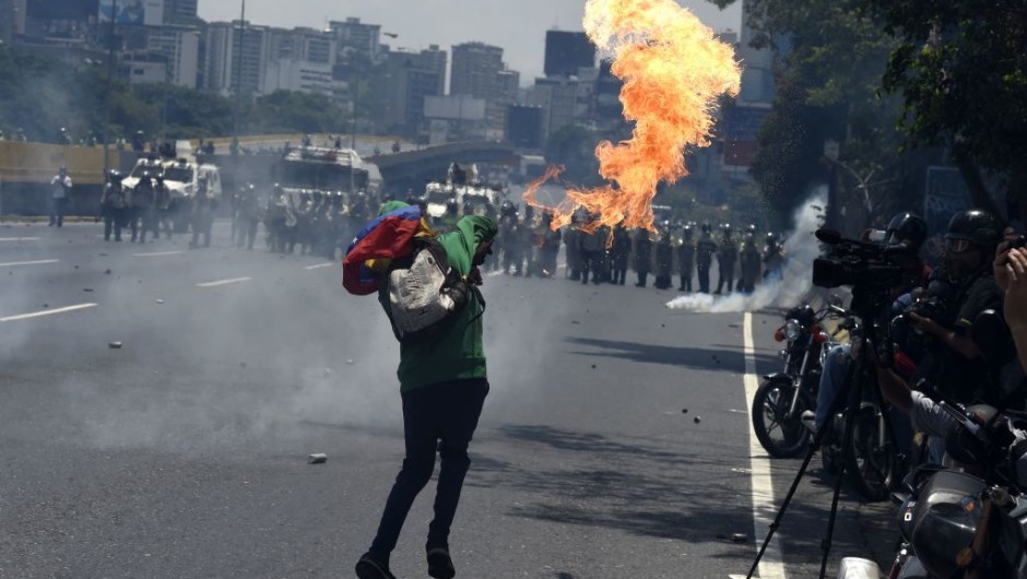 Opposition demonstrators clash with riot police during a march in Caracas on April 26, 2017. Protesters in Venezuela plan a high-risk march against President Maduro Wednesday, sparking fears of fresh violence after demonstrations that have left 26 dead in the crisis-wracked country. The placard reads "Jailed Students and Loose Delinquents" / AFP PHOTO / JUAN BARRETO (Photo credit should read JUAN BARRETO/AFP/Getty Images)