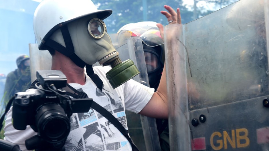 A journalists argues with riot police as opposition activists clash with police during a protest march in Caracas on April 26, 2017. Protesters in Venezuela plan a high-risk march against President Maduro Wednesday, sparking fears of fresh violence after demonstrations that have left 26 dead in the crisis-wracked country. / AFP PHOTO / RONALDO SCHEMIDT (Photo credit should read RONALDO SCHEMIDT/AFP/Getty Images)