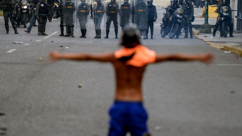 TOPSHOT - Opposition activists clash with riot police during a protest against President Nicolas Maduro in Caracas on April 26, 2017. Venezuelan riot police fired tear gas to stop anti-government protesters from marching on central Caracas, the latest clash in a wave of unrest that, up to now, has left 26 people dead. / AFP PHOTO / FEDERICO PARRA (Photo credit should read FEDERICO PARRA/AFP/Getty Images)