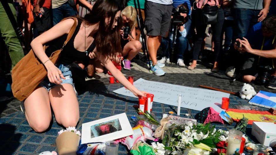 A woman displays candles on the Rambla boulevard for the victims of the Barcelona attack on August 18, 2017, a day after a van ploughed into the crowd, killing 13 persons and injuring over 100 on the Rambla in Barcelona. Drivers have ploughed on August 17, 2017 into pedestrians in two quick-succession, separate attacks in Barcelona and another popular Spanish seaside city, leaving 13 people dead and injuring more than 100 others. In the first incident, which was claimed by the Islamic State group, a white van sped into a street packed full of tourists in central Barcelona on Thursday afternoon, knocking people out of the way and killing 13 in a scene of chaos and horror. Some eight hours later in Cambrils, a city 120 kilometres south of Barcelona, an Audi A3 car rammed into pedestrians, injuring six civilians -- one of them critical -- and a police officer, authorities said. / AFP PHOTO / Josep LAGO (Photo credit should read JOSEP LAGO/AFP/Getty Images)