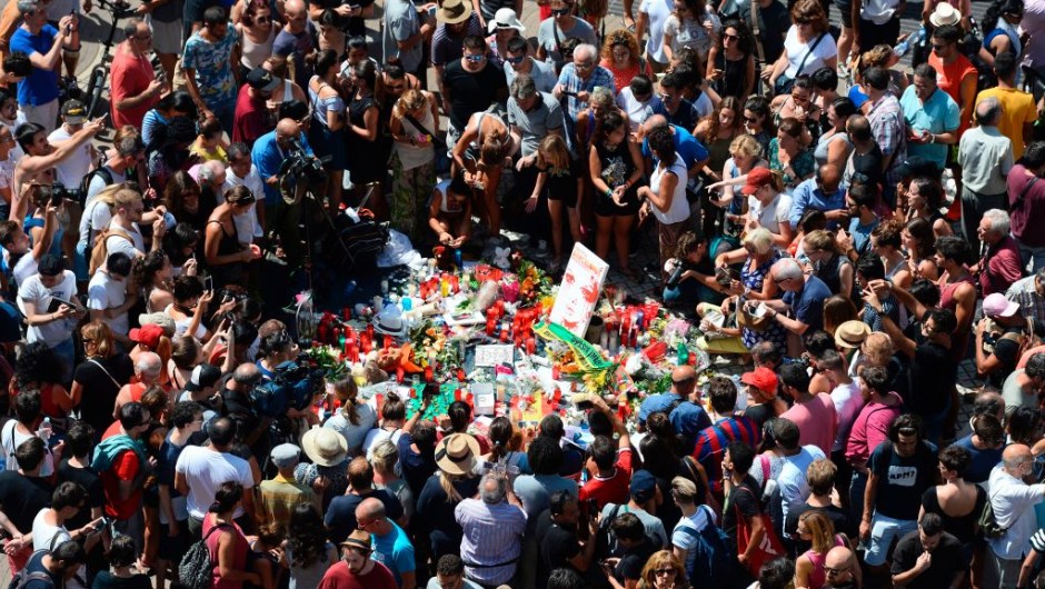 TOPSHOT - People gather to leave candles, flowers, messages, stuffed toys and many differents objects for the victims on August 18, 2017 at the spot where yesterday a van ploughed into the crowd, killing 14 persons and injuring over 100 on the Rambla boulevard in Barcelona. Drivers have ploughed on August 17, 2017 into pedestrians in two quick-succession, separate attacks in Barcelona and another popular Spanish seaside city, leaving 14 people dead and injuring more than 100 others. In the first incident, which was claimed by the Islamic State group, a white van sped into a street packed full of tourists in central Barcelona on Thursday afternoon, knocking people out of the way and killing 13 in a scene of chaos and horror. Some eight hours later in Cambrils, a city 120 kilometres south of Barcelona, an Audi A3 car rammed into pedestrians, injuring six civilians -- one of them critical -- and a police officer, authorities said. / AFP PHOTO / Josep LAGO (Photo credit should read JOSEP LAGO/AFP/Getty Images)