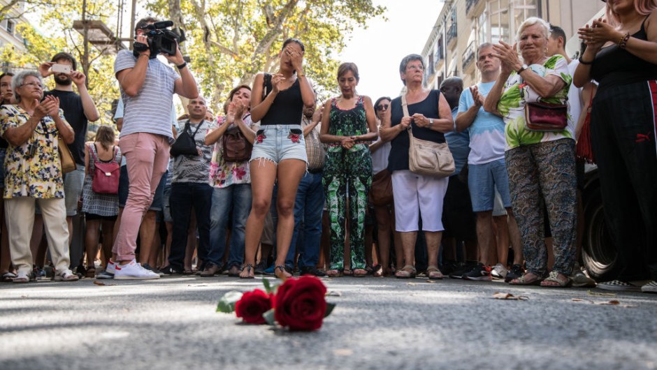 BARCELONA, SPAIN - AUGUST 18: People gather around roses laid on the ground on Las Ramblas after a one minute's silence for the victims of yesterday's terrorist attack, on August 18, 2017 in Barcelona, Spain. Fourteen people were killed and dozens injured when a van hit crowds in the Las Ramblas area of Barcelona on Thursday. Spanish police have also killed five suspected terrorists in the town of Cambrils to stop a second terrorist attack. (Photo by Carl Court/Getty Images)