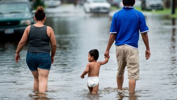 People walk through flooded streets as the effects of Hurricane Henry are seen August 26, 2017 in Galveston, Texas.
