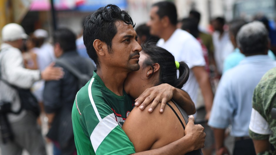 A couple embraces on September 8, 2017 in Juchitan de Zaragoza, state of Oaxaca, where buildings collapsed after an 8.2 earthquake that hit Mexico's Pacific coast overnight. Mexico's most powerful earthquake in a century killed at least 35 people, officials said, after it struck the Pacific coast, wrecking homes and sending families fleeing into the streets. / AFP PHOTO / Pedro PARDO (Photo credit should read PEDRO PARDO/AFP/Getty Images)