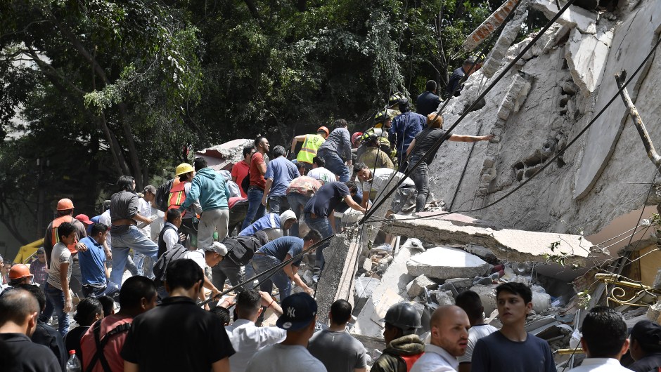 People remove debris of a collapsed building looking for possible victims after a quake rattled Mexico City on September 19, 2017. A powerful earthquake shook Mexico City on Tuesday, causing panic among the megalopolis' 20 million inhabitants on the 32nd anniversary of a devastating 1985 quake. The US Geological Survey put the quake's magnitude at 7.1 while Mexico's Seismological Institute said it measured 6.8 on its scale. The institute said the quake's epicenter was seven kilometers west of Chiautla de Tapia, in the neighboring state of Puebla. / AFP PHOTO / Omar TORRES (Photo credit should read OMAR TORRES/AFP/Getty Images)