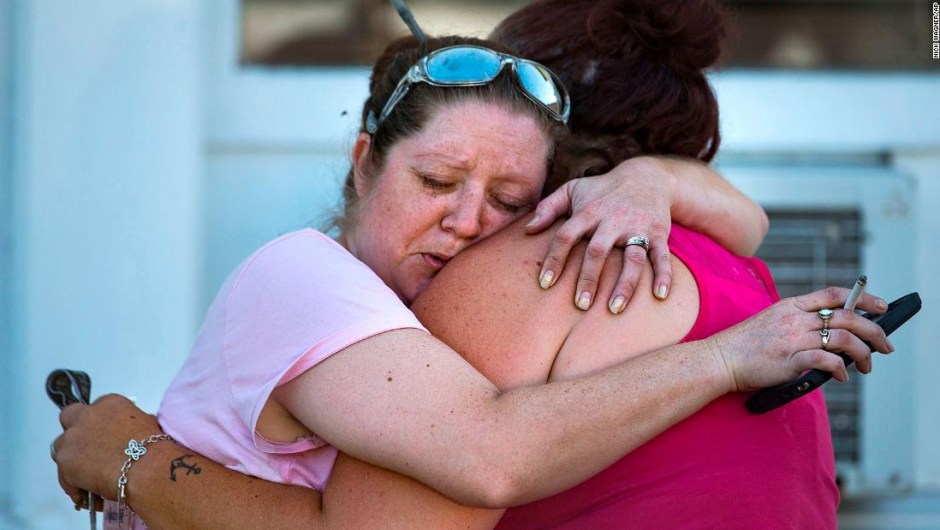 Carrie Matula abraza a una mujer después del tiroteo en la iglesia. Matula dijo que escuchó los disparos desde la gasolinera donde trabaja al otro lado de la calle.