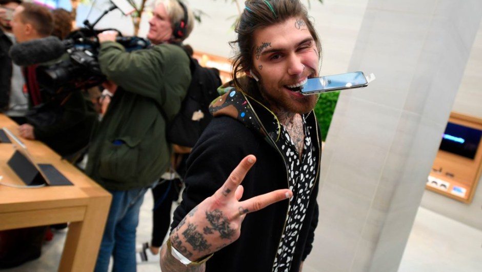 Marco White Jr., son of British chef Marco Pierre White poses with his Apple iPhone X after being one of the first to purchase the newly released smartphone at Apple's Regent Street store in central London on November 3, 2017. Apple's flagship iPhone X hit stores on November 3, as the world's most valuable company predicted bumper sales despite the handset's eye-watering price tag and celebrated a surge in profits. The device features facial recognition, cordless charging and an edge-to-edge screen made of organic light-emitting diodes used in high-end televisions. It marks the 10th anniversary of the first iPhone release and is released in about 50 markets around the world. / AFP PHOTO / Chris J Ratcliffe (Photo credit should read CHRIS J RATCLIFFE/AFP/Getty Images)