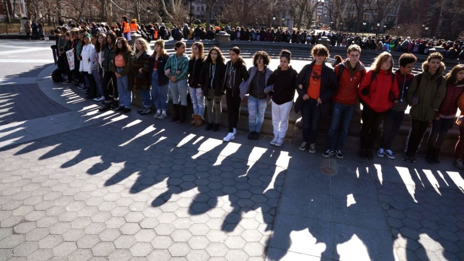 Students from Harvest Collegiate High School form a circle around the fountain in Washington Square Park on March 14, 2018 in New York to take part in a national walkout to protest gun violence, one month after the shooting in Parkland, Florida, in which 17 people were killed. Students across the US walked out of classes on March 14, in a nationwide call for action against gun violence following the shooting deaths last month at a Florida high school. The nationwide protest is being held one month to the day after Nikolas Cruz, a troubled 19-year-old former student at Stoneman Douglas, unleashed a hail of gunfire on his former classmates. / AFP PHOTO / TIMOTHY A. CLARY (Photo credit should read TIMOTHY A. CLARY/AFP/Getty Images)