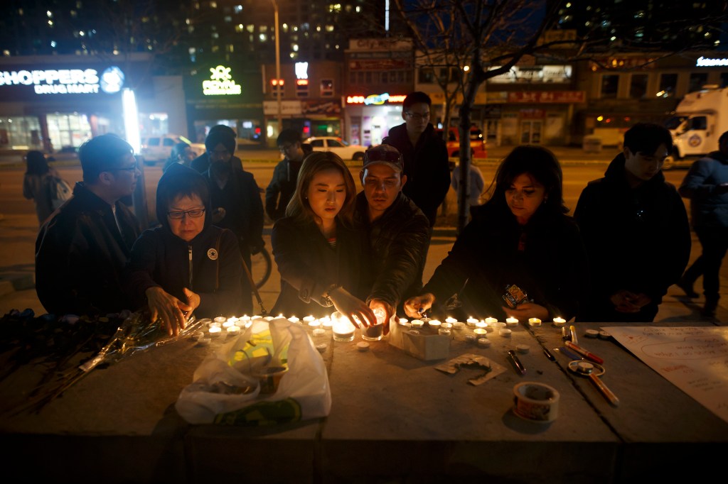 Personas dejan velas y mensajes en el lugar en el que tuvo lugar un atropello masivo que dejó varios muertos en Toronto (Canadá) durante la noche del 23 de abril de 2018. (Crédito: Cole Burston/Getty Images)