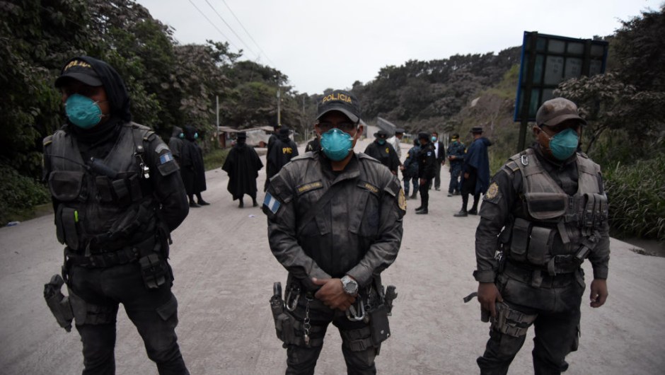 TOPSHOT - Police officers are posted in Alotenango municipality, Sacatepequez department, about 65 km southwest of Guatemala City, as the Fuego Volcano erupts on June 3, 2015. (Photo by ORLANDO ESTRADA / AFP) (Photo credit should read ORLANDO ESTRADA/AFP/Getty Images)