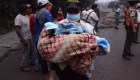 TOPSHOT - A police officer carries a baby after the eruption of the Fuego Volcano, in El Rodeo village, Escuintla department, 35 km south of Guatemala City on June 3, 2018. (Photo by NOE PEREZ / AFP) (Photo credit should read NOE PEREZ/AFP/Getty Images)