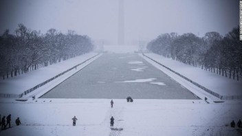 Rare tourists walk by the Lincoln Memorial Reflecting pool as snow is accumulating in Washington DC on January 13, 2019. - Washington area residents are waking up to a winter wonderland, and may need to shovel aside several inches of snow that fell overnight as a winter storm warning remains in effect until 6 p.m. Sunday and more snow is expected to fall. (Photo by Eric BARADAT / AFP) (Photo credit should read ERIC BARADAT/AFP/Getty Images)