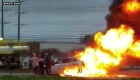 Varios hombres sacan a una mujer de un vehículo en llamas