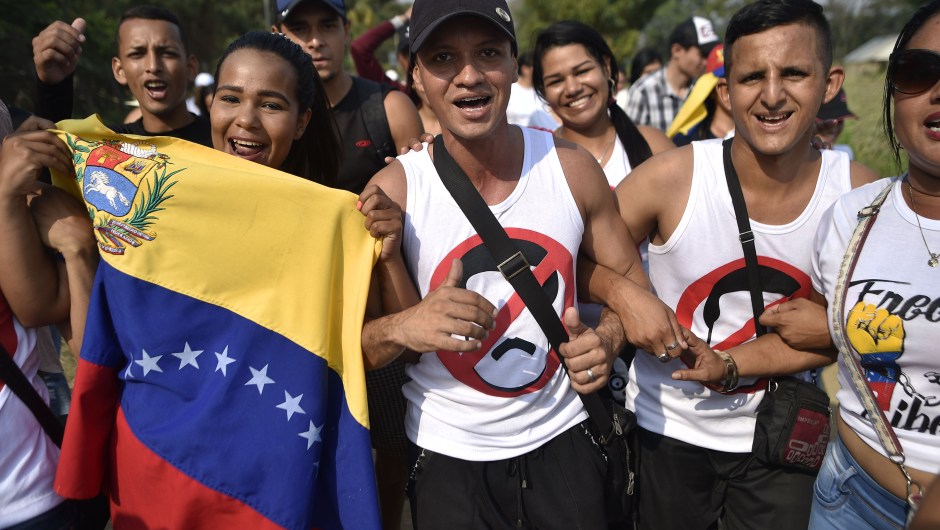 People carry Venezuelan flags as they walk to the place where "Venezuela Aid Live" concert will be held at Tienditas International Bridge in Cucuta, Colombia, on February 22, 2019. - The concert was organized by British billionaire Richard Branson to raise money for the Venezuelan relief effort. Venezuela's political tug-of-war morphs into a battle of the bands on Friday, with dueling government and opposition pop concerts ahead of a weekend showdown over the entry of badly needed food and medical aid. (Photo by Luis ROBAYO / AFP) (Photo credit should read LUIS ROBAYO/AFP/Getty Images)