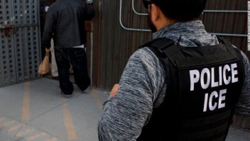 Two United States Immigration and Customs Enforcement (ICE) agents observe as an undocumented man is being received by a Mexican immigration agent at a removal gate at the U.S.-Mexico border on February 26, 2015 in San Diego, California, USA. (David Maung/Bloomberg)
