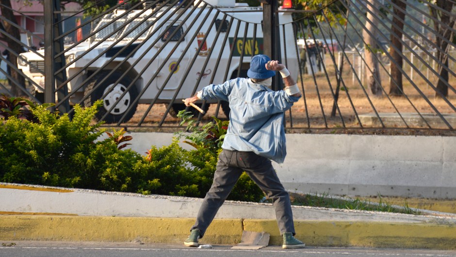 Un manifestante lanza una piedra a un vehículo de la Guardia Nacional el 30 de abril de 2019 en Caracas, Venezuela. Crédito: de Rafael Briceno / Getty Images