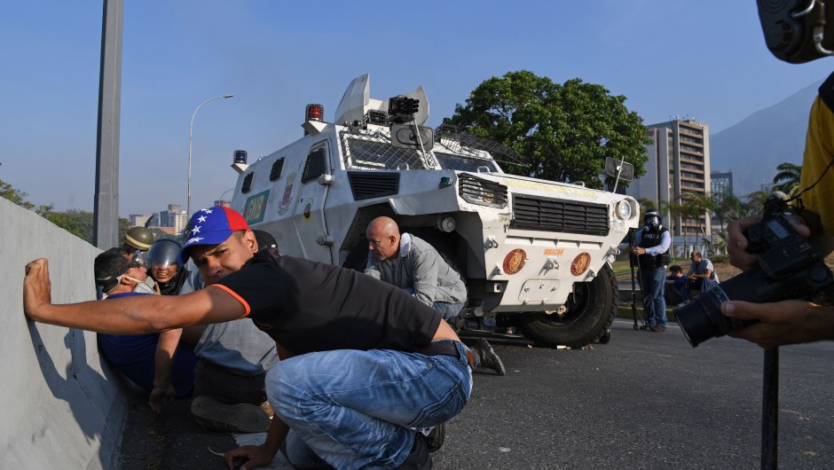 Venezolanos se protegen durante los enfrentamientos con las fuerzas de seguridad en Caracas el 30 de abril de 2019. Crédito: YURI CORTEZ / AFP / Getty Images