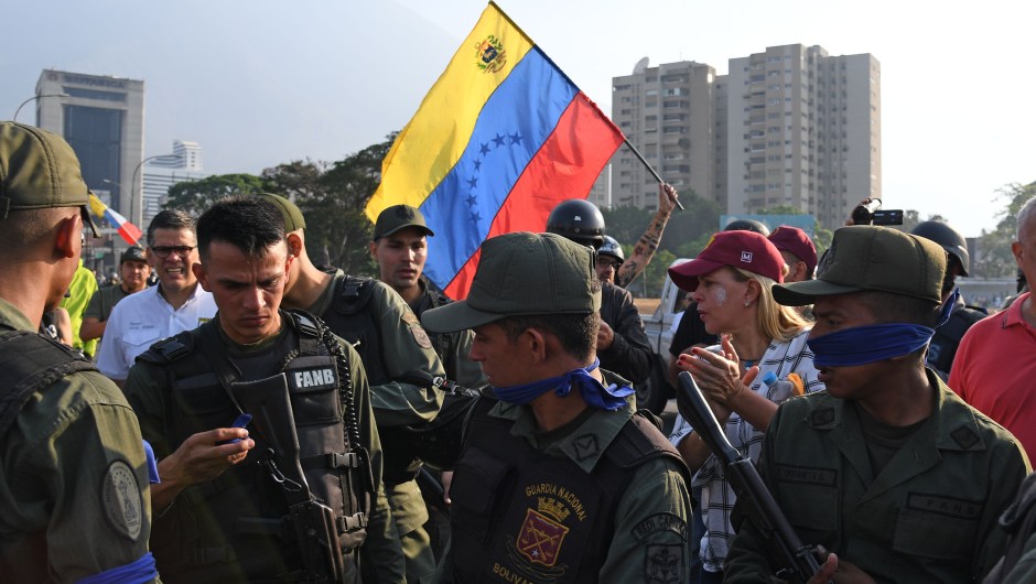 Un grupo de personas junto a miembros de las fuerzas de seguridad en Caracas el 30 de abril de 2019. Crédito: YURI CORTEZ / AFP / Getty Images