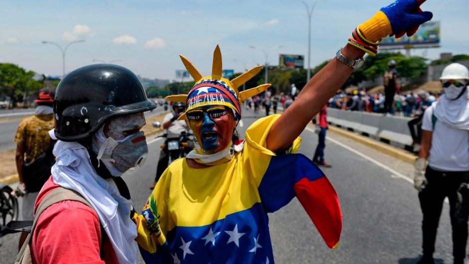 Anti-government protesters take part in a march in Caracas to commemorate May Day on May 1, 2019 after a day of violent clashes on the streets of the capital spurred by Venezuela's opposition leader Juan Guaido's call on the military to rise up against President Nicolas Maduro. - Guaido called for a massive May Day protest to increase the pressure on President Maduro. (Photo by Matias Delacroix / AFP) (Photo credit should read MATIAS DELACROIX/AFP/Getty Images)