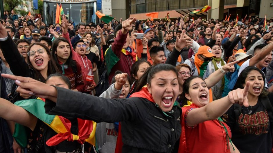 Supporters of Bolivia's main opposition presidential candidate, former president (2003-2005) Carlos Mesa, shout slogans against supporters of president and candidate Evo Morales, as both groups gather outside the hotel where the Supreme Electoral Tribunal has its headquarters to count the election votes, in La Paz, on October 21, 2019. - Evo Morales, seeking a controversial fourth term, led Bolivia's presidential election race Sunday but faces a historic second round run-off against Mesa, partial results showed. Morales had 45 percent of the vote to Mesa's 38 percent, the Supreme Electoral Tribunal announced, with most of the votes counted. (Photo by Aizar RALDES / AFP) (Photo by AIZAR RALDES/AFP via Getty Images)