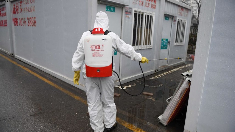 A worker disinfects between containers at the Youan Hospital in Beijing on February 14, 2020. - Youan Hospital is one of twenty hospitals in Beijing treating coronavirus patients. Six health workers have died from the COVID-19 coronavirus in China and more than 1,700 have been infected, health officials said on February 14, underscoring the risks doctors and nurses have taken due to shortages of protective gear. (Photo by GREG BAKER / AFP) (Photo by GREG BAKER/AFP via Getty Images)