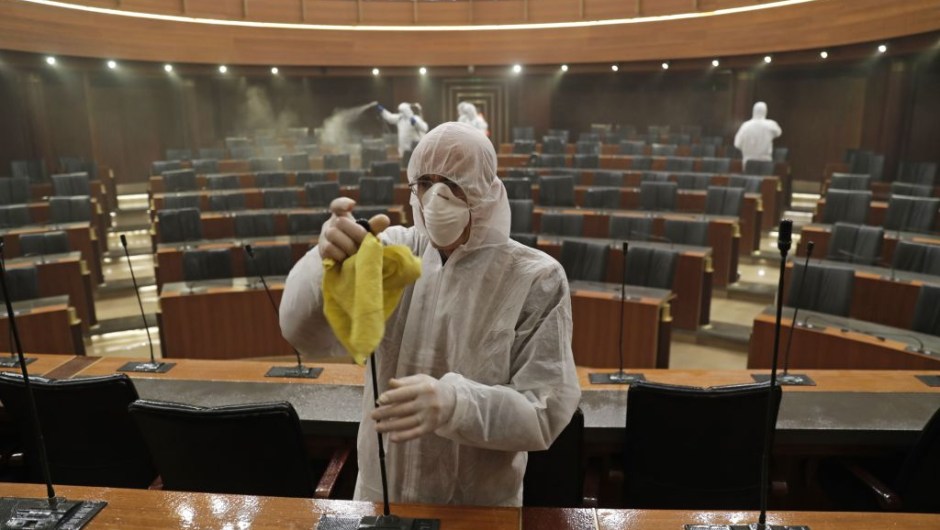 TOPSHOT - Sanitary workers disinfect the desks and chairs of the Lebanese Parliament in central Beirut on March 10, 2020 amid the spread of coronavirus in the country. (Photo by ANWAR AMRO / AFP) (Photo by ANWAR AMRO/AFP via Getty Images)