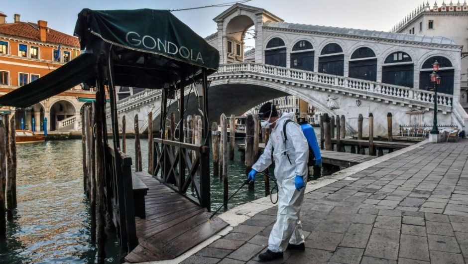 TOPSHOT - An employee of the municipal company Veritas sprays disinfectant in public areas at the Rialto Bridge in Venice on March 11, 2020, as part of precautionary measures against the spread of the new coronavirus COVID-19, a day after Italy imposed unprecedented national restrictions on its 60 million people Tuesday to control the deadly COVID-19 coronavirus. (Photo by MARCO SABADIN / AFP) (Photo by MARCO SABADIN/AFP via Getty Images)