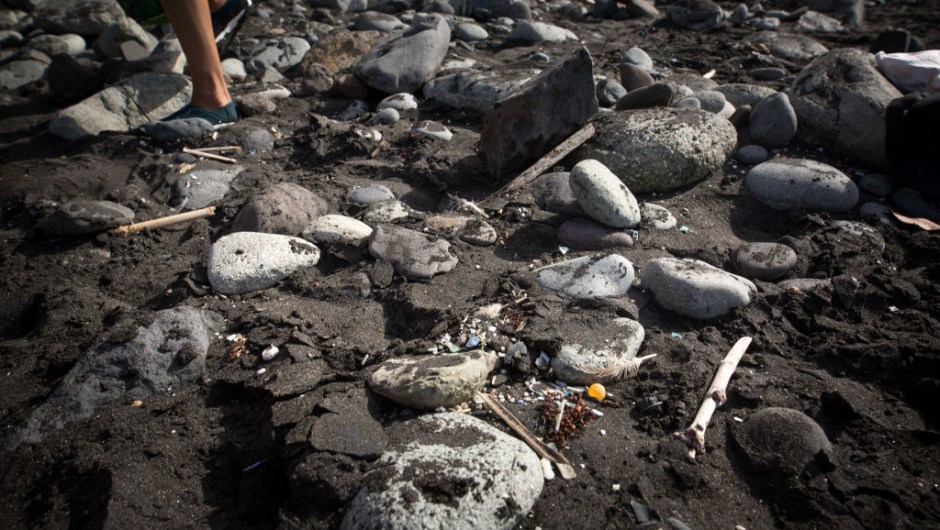 A volunteer of the NGO 'Canarias Libre de Plasticos' (Canary Islands free of plastics) carries out a collection of microplastics and mesoplastic debris to clean the Almaciga Beach, on the north coast of the Canary Island of Tenerife, on July 14, 2018. (Photo by DESIREE MARTIN / AFP) (Photo credit should read DESIREE MARTIN/AFP via Getty Images)