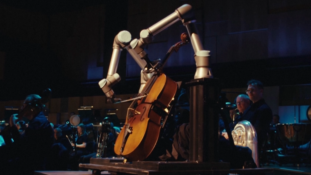 Mira al robot que toca el violonchelo toca junto a una orquesta por primera vez