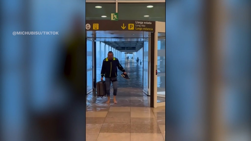 Personas caminan descalzas por el aeropuerto de Barcelona debido a las inundaciones