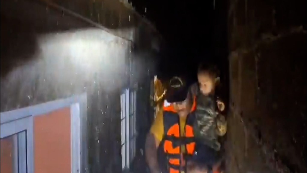 Bomberos evacuan a familias de las inundaciones en Honduras provocadas por la tormenta tropical Sara