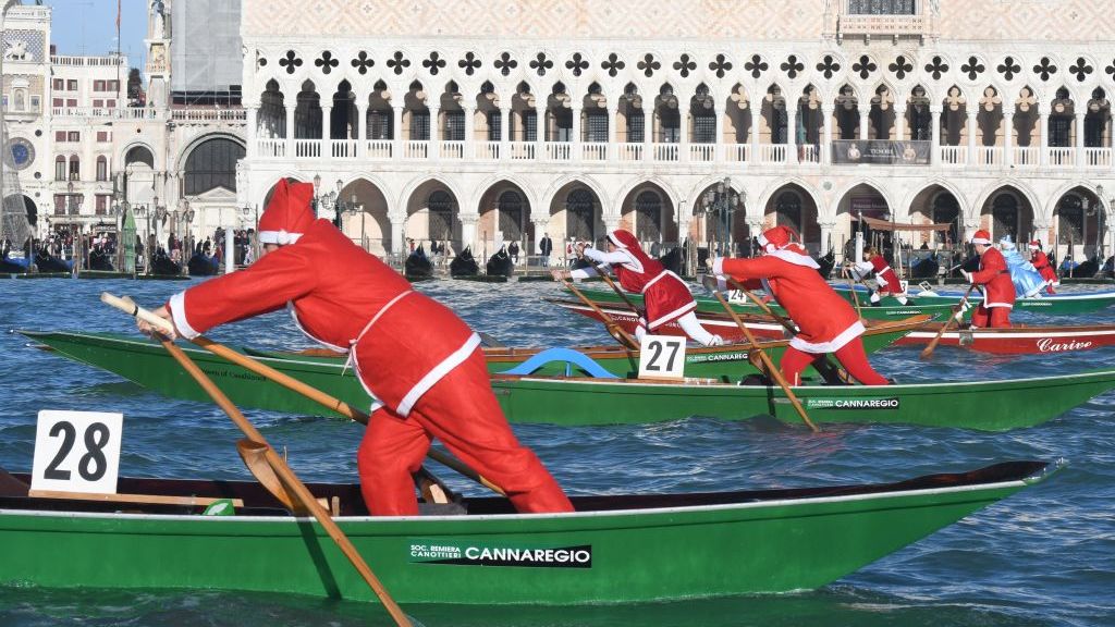 Cientos de Santa Claus desfilan en góndolas a unos días de la Navidad en Venecia